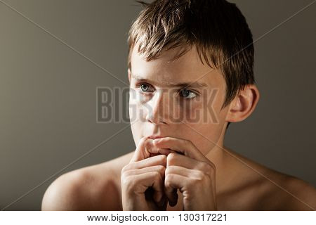 Thoughtful Boy With Hands In Front Of Mouth