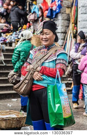 YUANYANG, CHINA - FEBRUARY 28,2016 : Unidentified Hani woman poses for a photo in market, The Hani or Ho people are an ethnic group of Southeast Asia