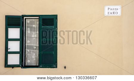 a green window in the Lighthouse Square in Punta Secca Ragusa