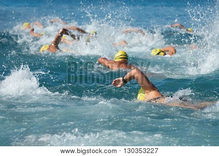 Swimming athletes in a triathlon contest in the sea