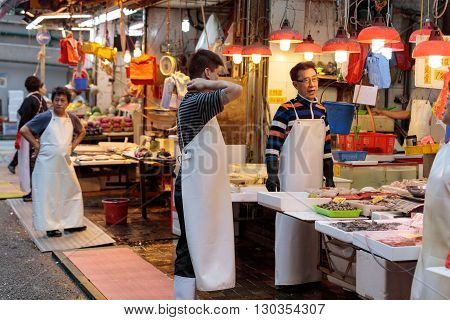 Hong Kong, Special Administrative Region of the People's Republic of China - 19 April 2016: Asian man selling seafood on traditional wet market