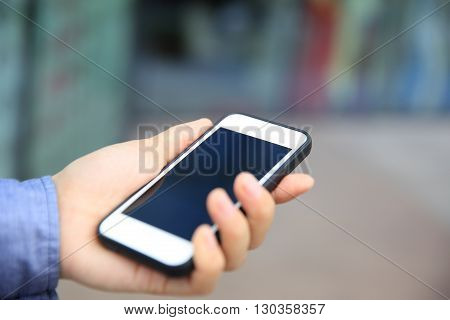 female hand with smart phone in city