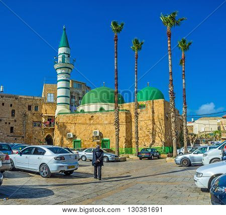ACRE ISRAEL - FEBRUARY 20 2016: The old stone E-Zaitune Mosque with the white minaret and bright green domes located next to the Turkish Bazaar on February 20 in Acre.