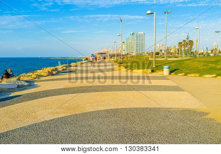 TEL AVIV ISRAEL - FEBRUARY 25 2016: The seaside promenade of the city is the popular place for the walks or jogging on February 25 in Tel Aviv.