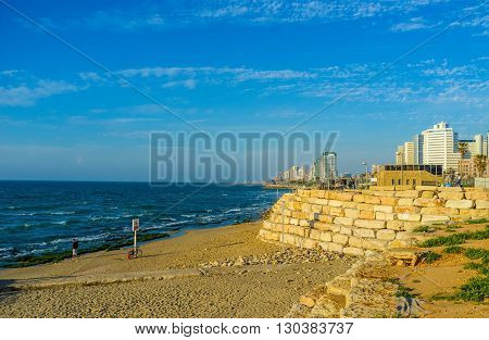 TEL AVIV ISRAEL - FEBBRUARY 25 2016: The seashore with the narrow Alma beach line and modern high-rises on the background on February 25 in Tel Aviv.