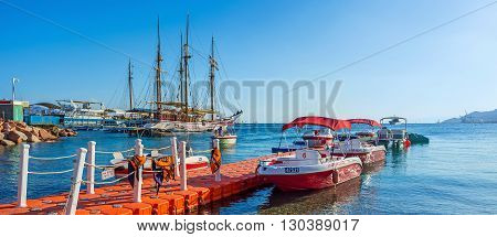 EILAT ISRAEL - FEBRUARY 23 2016: The small speedboats for the incredible sightseeing experience and the large wooden sailing ships for the romantic voyages on February 23 in Eilat.