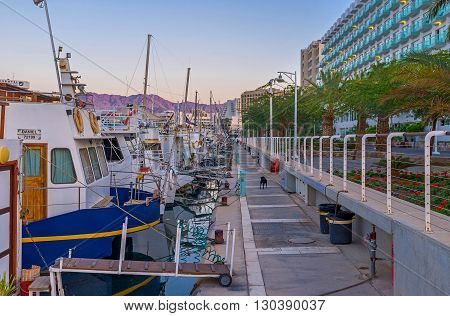 EILAT ISRAEL - FEBRUARY 23 2016: The evening promenade along the moored yachts in port on February 23 in Eilat.