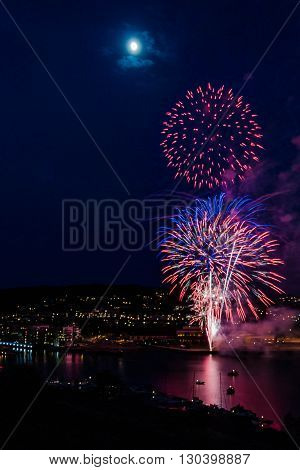 Show of fireworks at the finish of the celebration of the National Day of acceptance on the anniversary of the Norwegian Constitution - May, 17, 2016, Tonsberg, Norway
Can see on picture city by night with port on the Oslofjord port with buildings port.