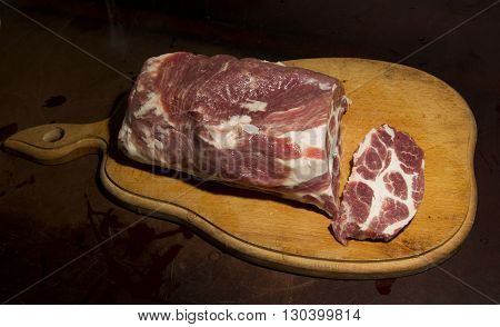 Fresh raw meat on a cutting wooden board