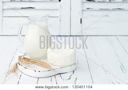 Soft homemade fresh ricotta cottage cheese made from milk draining on muslin cloth. Tzfat cheese with wheat grains. Symbols of judaic holiday Shavuot.