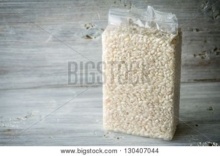 Packaging with Arborio rice on wooden boards horizontal
