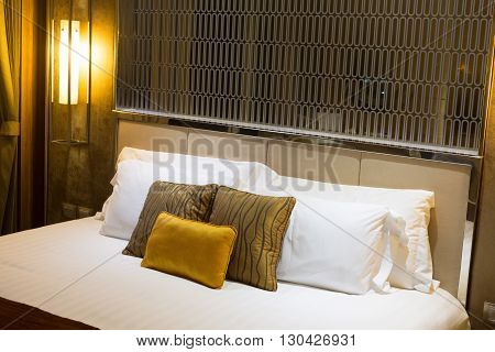 Pillows on a bed in a hotel brown and yellow.