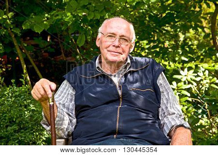Elderly Man Sitting In The Garden
