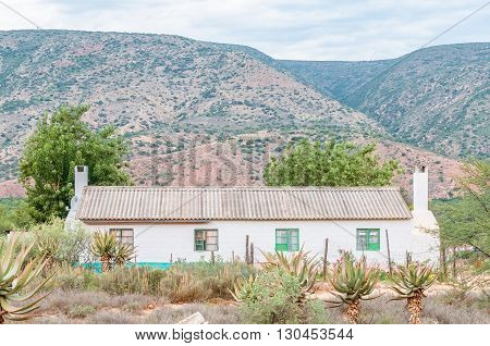 A farm worker duet house with aloes in front in the Baviaanskloof (baboon valley).
