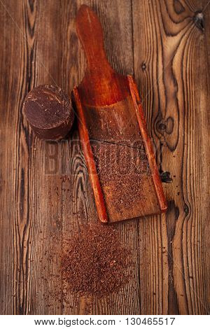grated 100% dark chocolate flakes on vintage  wooden grate,   shallow DOF
