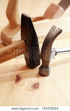 Two hammers near plane on wooden workbench