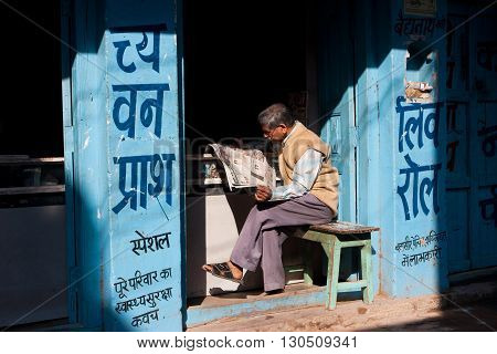 CHITRAKOOT, INDIA - DEC 29, 2012: Elderly asian man read a newspaper at sunny morning on December 29, 2012 in Chitrakoot India. Chitrakoot has an literacy rate of 50 perc lower than national average of 59.5 perc.