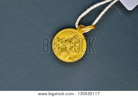 Golden scapular pendant traditionally given for first communion gift. Macro image.
