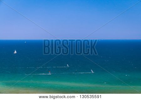Sea landscape with sailing ships and windsurfers