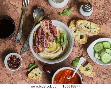 Delicious lunch - bean puree with bacon tomato sauce with carrots and onions homemade bread glass of red wine on a stone background. Top view