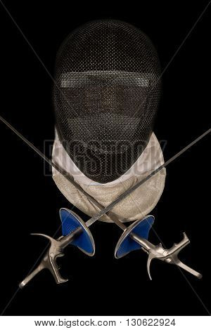 Fencing foil equipment. Two fencing foils with pistol grip and a fencing mask. Isolated on black background