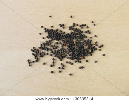 Canola seeds for oil on wooden board