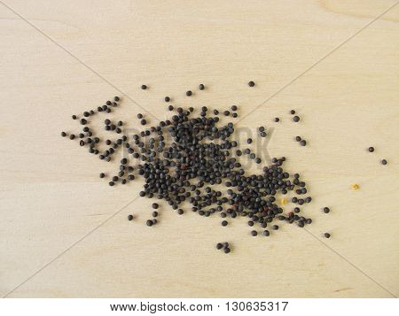 Canola seeds for oil on wooden board