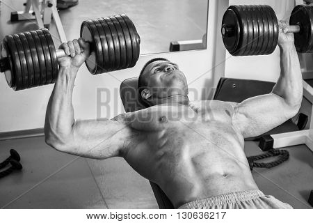 Strong man. Muscle training in the gym. Training in the gym.