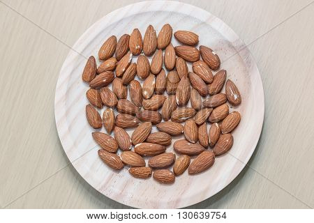 Some almonds in a wooden bowl view from above