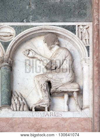 LUCCA, ITALY - JUNE 06, 2015: January, detail of the bas-relief representing the Labor of the months of the year, portal of the Cathedral of St Martin in Lucca, Italy, on June 06, 2015