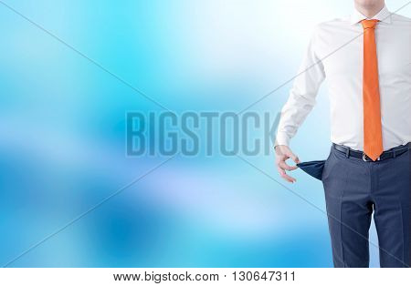 Unemployment concept with businessman showing empty pockets on abstract blue background