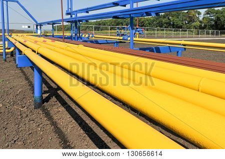 Yellow gas pipes in natural gas treatment plant in bright sunny summer day