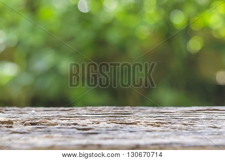 Old wooden table with green blur bokhe background