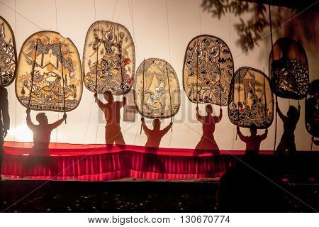RATCHABURI THAILAND - APRIL 14 2015: The Cowskin shows a man holding a stencil pattern. Moving Cowskin the light to shadow play. The musical atmosphere and read a poem composed. In a traditional culture. There are performances every year Thailand in SONGK