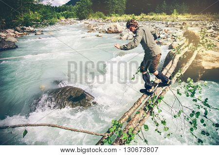 Man Traveler crossing over river on woods outdoor Lifestyle Travel extreme survival concept