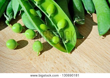 fresh pod green peas on wood background