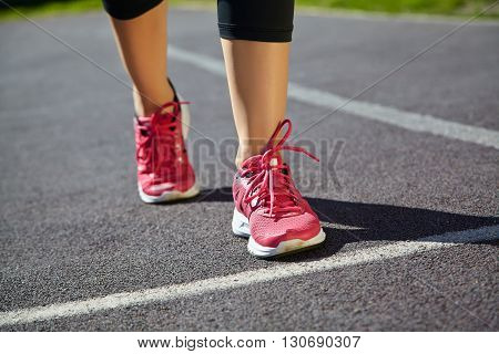 selective focus. runner feet closeup. athlete running on jogging track at the stadium in running shoes. jogging outdoors