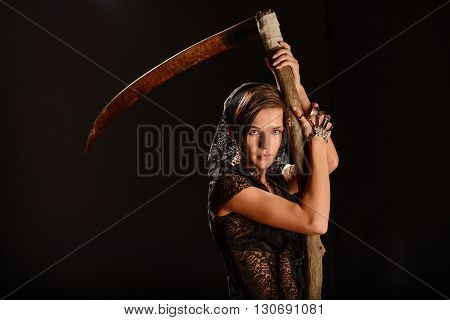 Girl in a black lace smock with a scythe of death. concept