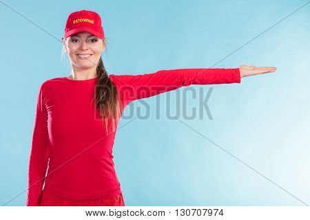 Happy Lifeguard Woman In Cap Pointing Direction.