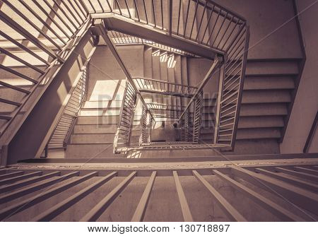 a moody stairwell taken from a top view and toned with a vintage retro instagram filter effect app or action