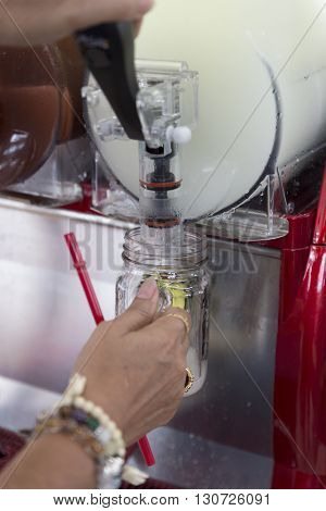 hand pulling cold ice slush fruit juice beverage equipment machine selective focus