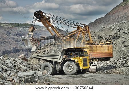 Excavator developing the iron ore on the opencast and loading it to the dump truck