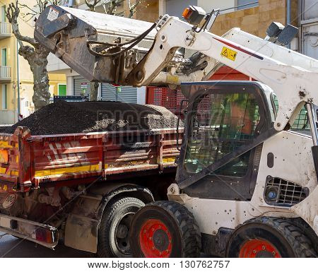 Sweeper attachments mini excavator. The sweeper sweeps collects and dumps dirt and debris.