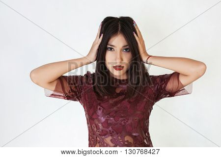 Young cute woman covering her ears isolated on a white background. Looking at camera