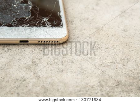 Close up of broken mobile phone or tablet droped on cement floor with copy space High key