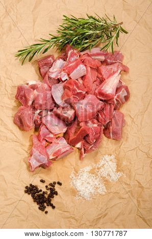 raw deer goulash with rosemary pepper corn and kosher salt on brown kitchen paper