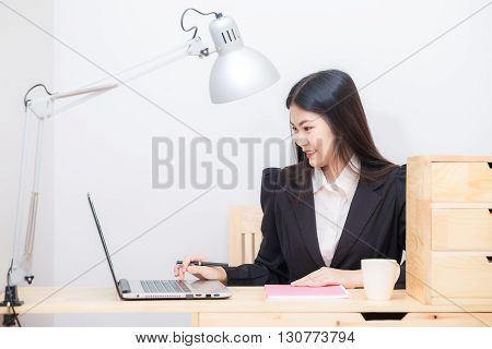 Portrait Of Business Asian Woman With Laptop Writes On A Document