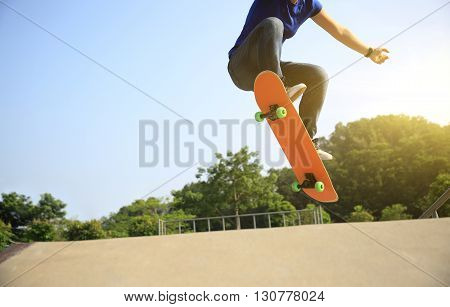 young woman skateboarder practice ollie at skatepark