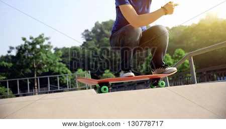 young woman skateboarder practice ollie at skatepark