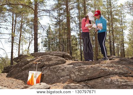 RUSSIA, ULAN-UDE - MAY 22, 2016: Russian Azimut - 2016. Orienteering competition is held annually in the Buryatia region. People at at control point at orienteering course.